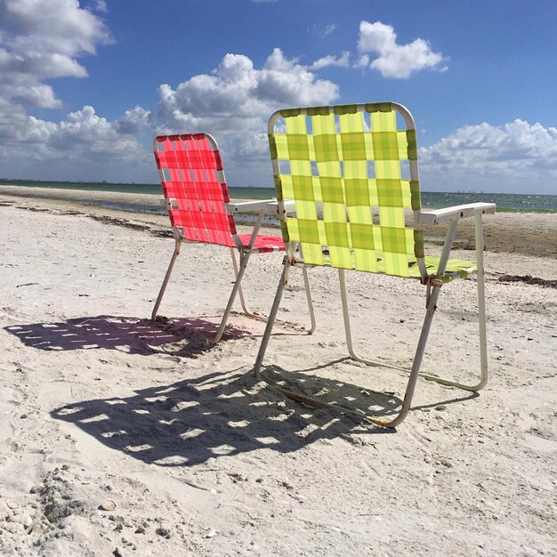 Photo lounge chairs on beach against sky