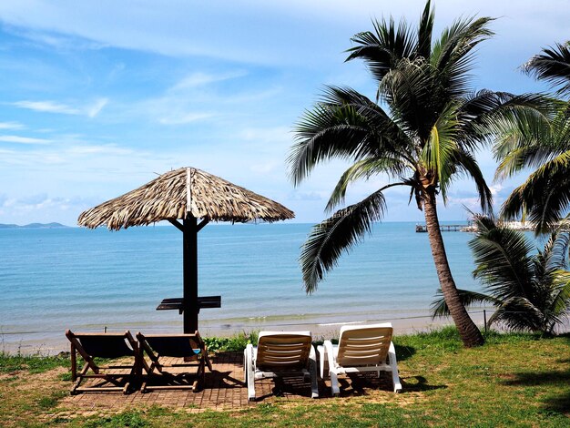 Photo lounge chairs on beach by sea against sky