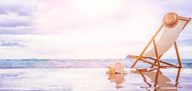 Lounger and bag on sand near sea