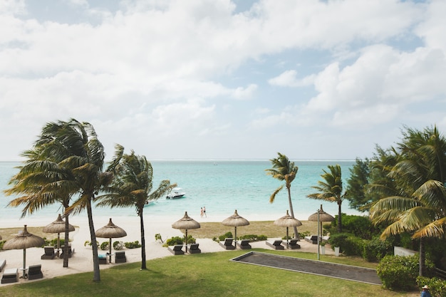 Lettini e ombrellone sulla spiaggia tropicale nell'isola di mauritius, oceano indiano