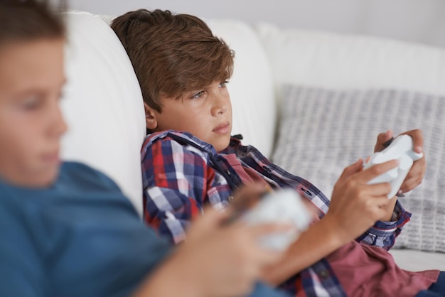 Loungin around Shot of two tired young boys sitting and playing video games