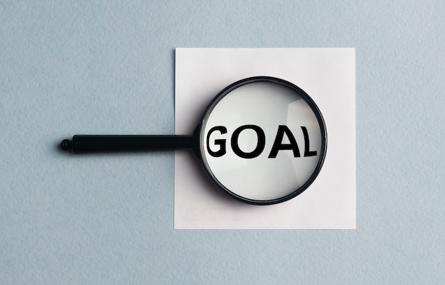 Photo loupe analysing the word goal on a white sticker on blue