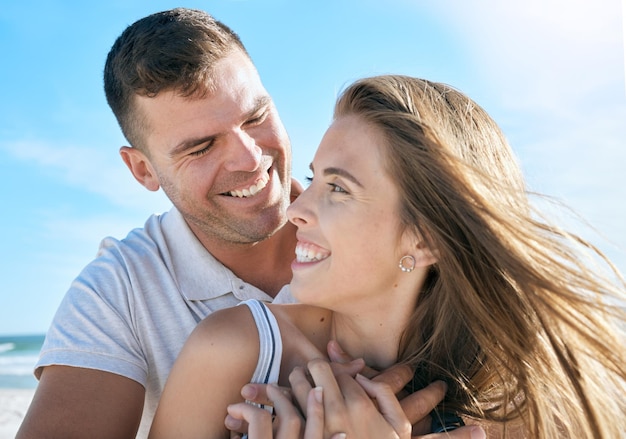 Love beach and summer with a couple outdoor together by the sea or ocean while on holiday Happy smile and travel with a man and woman bonding on the sunny coast during a romantic vacation