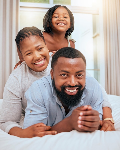 Love black family and with girl on bed happy or smile together for bonding loving and fun Portrait mother and father or parents with daughter in bedroom quality time and happiness on break