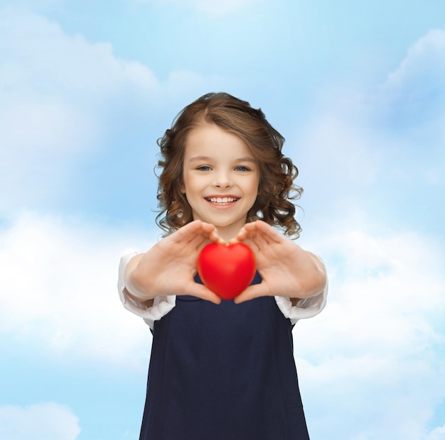 love, children and happiness concept - beautiful girl with small heart