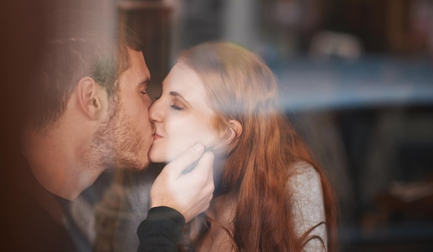 Love in a coffee shop A young couple sharing a kiss while on a date