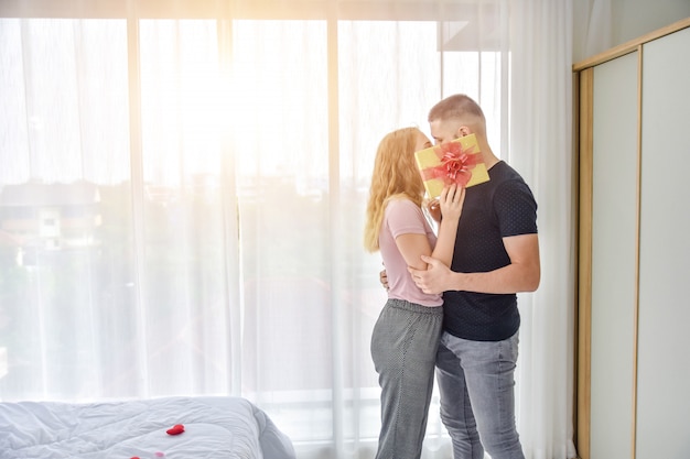 Love Couple giving gift box in bedroom happiness in love Valentine's day concept