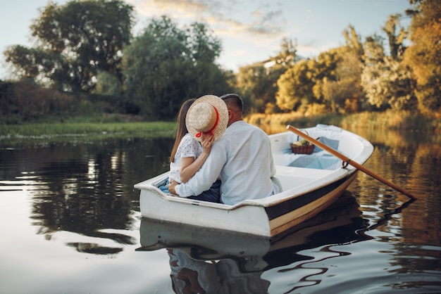 Love couple kissing in boat on lake