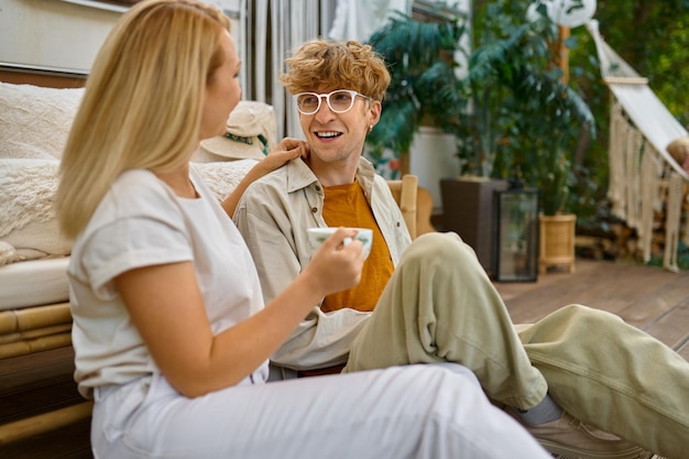 Love couple resting at the trailer, summer camping