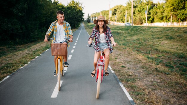 Amore coppia cavalcando biciclette retrò nel parco estivo