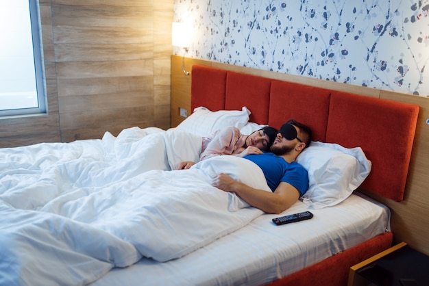 Love couple sleeping in eye covers in bed at home, healthy comfort sleep. Harmonious relationship in young family