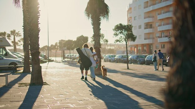 Love couple strolling palm avenue back view lovers walking dog crossing street