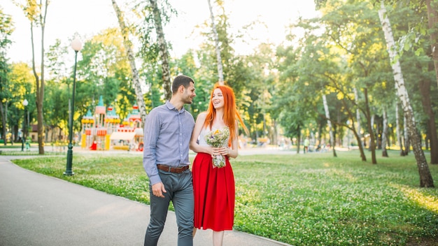 Amore coppia camminare e abbracci nel parco estivo