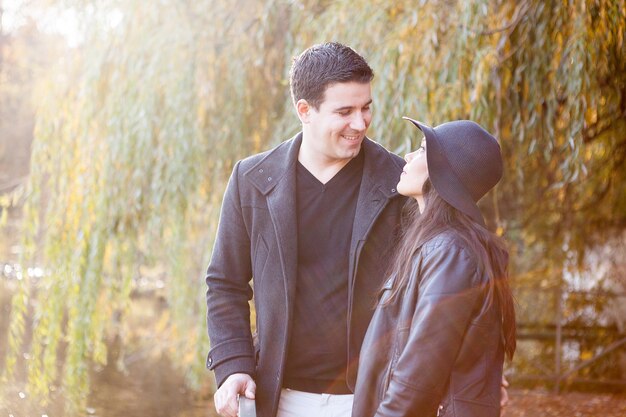 In love couple walking in autumn park near a lake