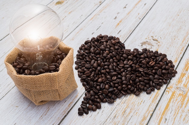 커피를 마시는 사랑, 심장 모양의 커피 콩, 전구는 에너지를 방출합니다.
