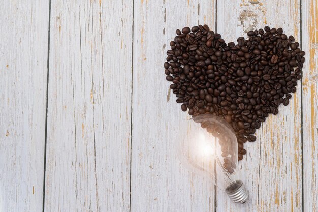 Photo love drinking coffee coffee beans in heart shape light bulbs emit energy