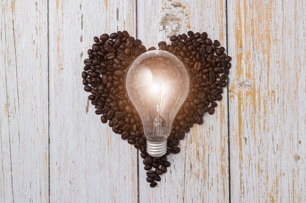 写真 コーヒーを飲むのが大好き、ハート型のコーヒー豆、電球はエネルギーを放出します。