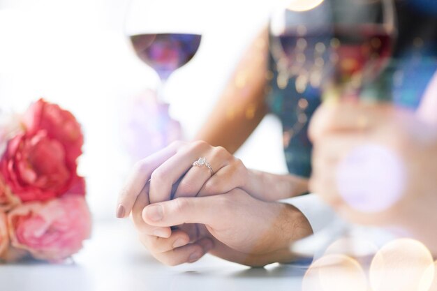 love, family, anniversary concept - engaged couple with wine glasses in restaurant