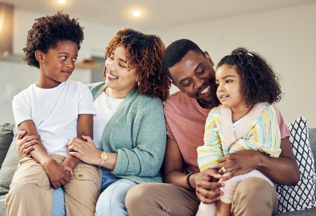 Love family and bond on a sofa happy and smile while talking and enjoying a morning in their home Relax children and parents on couch together embrace and loving in living room on weekend