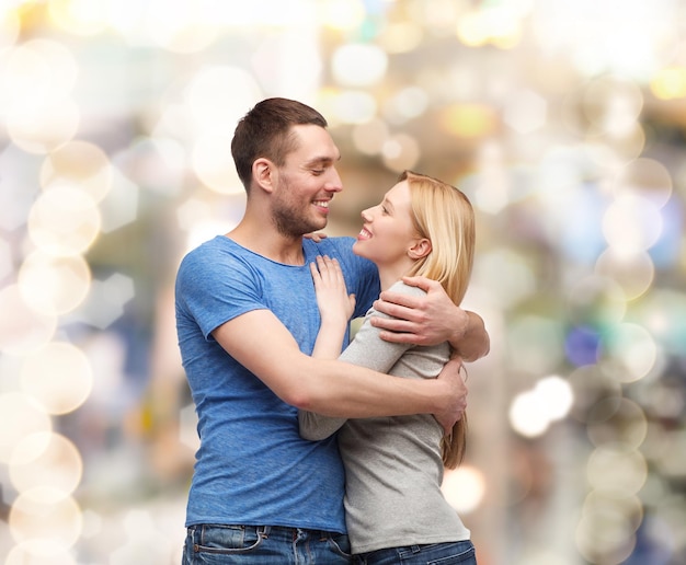 love and family concept - smiling couple hugging and looking at each other