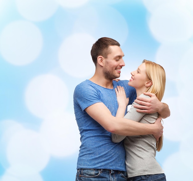 love and family concept - smiling couple hugging and looking at each other