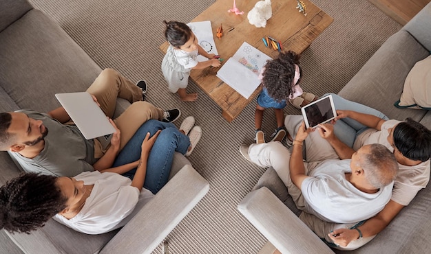 Love family and grandparents in home from above to bond with children in Mexico living room Grandparents parents and kids relax to enjoy leisure together with technology and color books