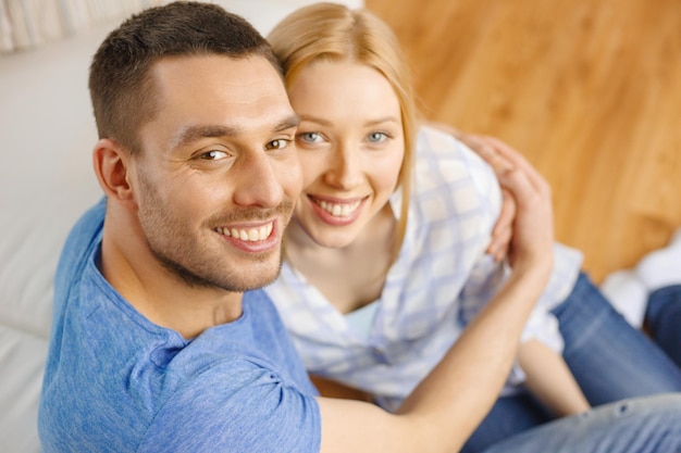 love, family and happiness concept - smiling happy couple at home