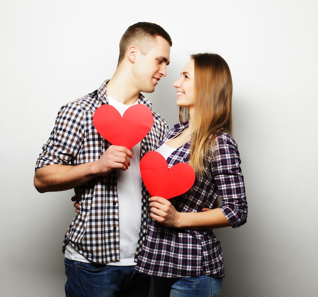 Love, family and people concept: Happy couple in love holding red heart.