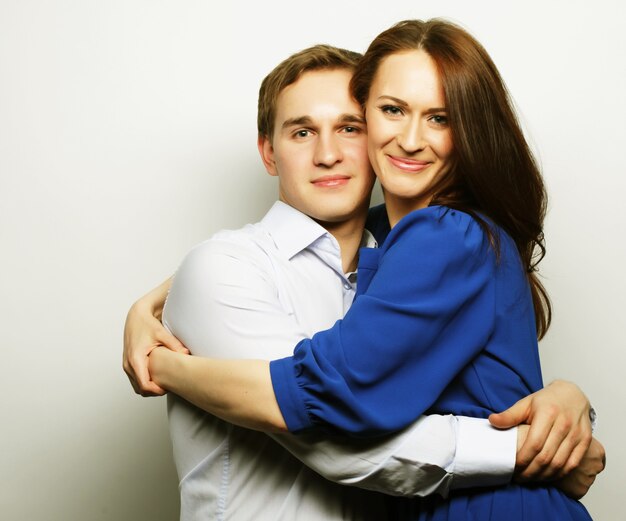 Love, family and people concept: lovely happy couple hugging over grey background.