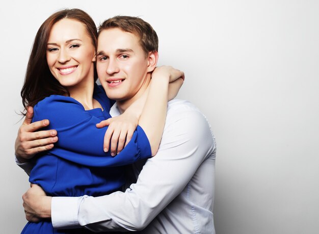 Love, family and people concept: lovely happy couple hugging over grey background.