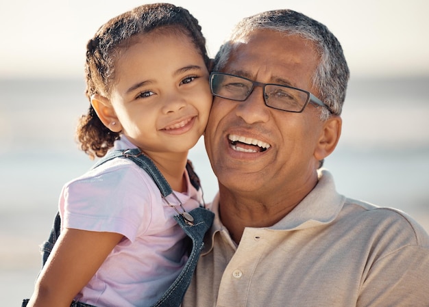 Love family and portrait of grandfather and child happy bonding and enjoy fun quality time by the beach Smile happiness and face of kid girl with elderly grandparent or senior man relax together