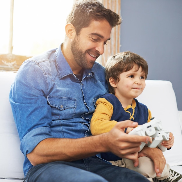 Foto amare padre e figlio con la felicità dei videogiochi e giocare a casa amare o sorridere genitore o papà di famiglia maschio con un ragazzo o un bambino con legame tecnologico o tempo di qualità con giochi o giochi