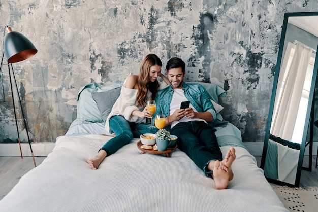 Love forever. Beautiful young couple having breakfast while spending time in bed at home