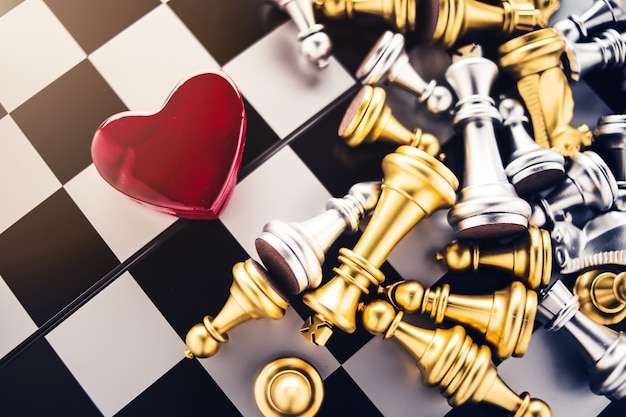 love games strategy concept with red heart with chess board game 