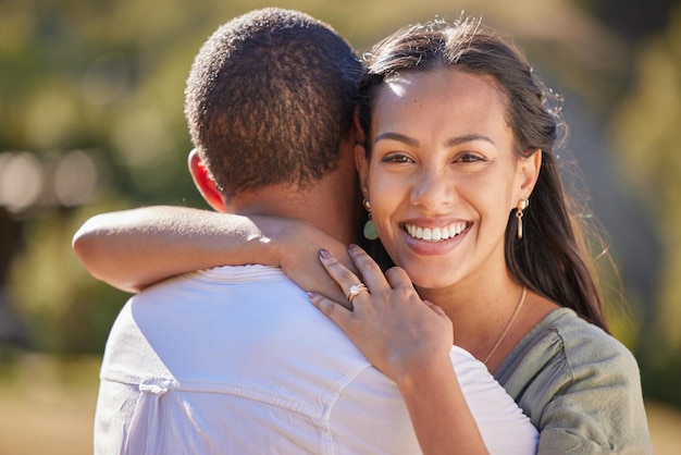 Love happiness and a couple hug in a park together Nature sunshine and man and woman hugging on an outdoor date Married life romance and affection happy lifestyle and loving smile on weekend