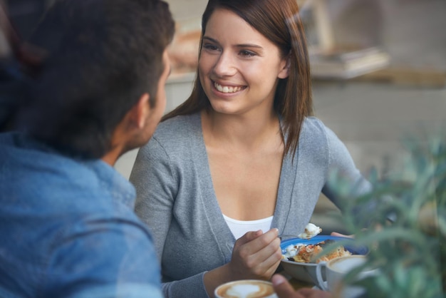 Photo love happy couple eating in coffee shop and drink in cafe for bonding together on valentines day date in the morning smile man and woman in restaurant with breakfast espresso food or conversation