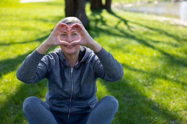 Photo love happy smiling woman showing heart sign