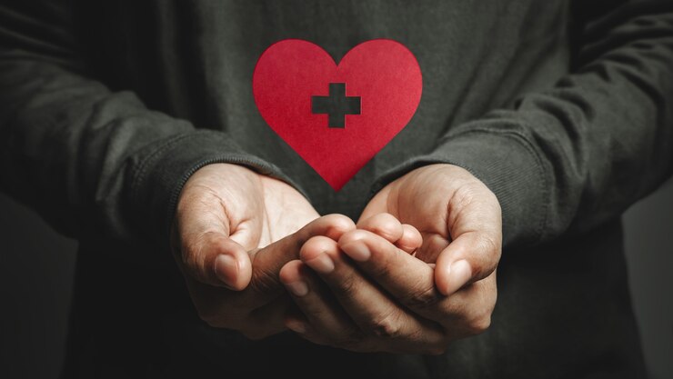 Love, Health Care, Donation and Charity Concept. Close up of Voluteer Levitating a Heart Shape Paper