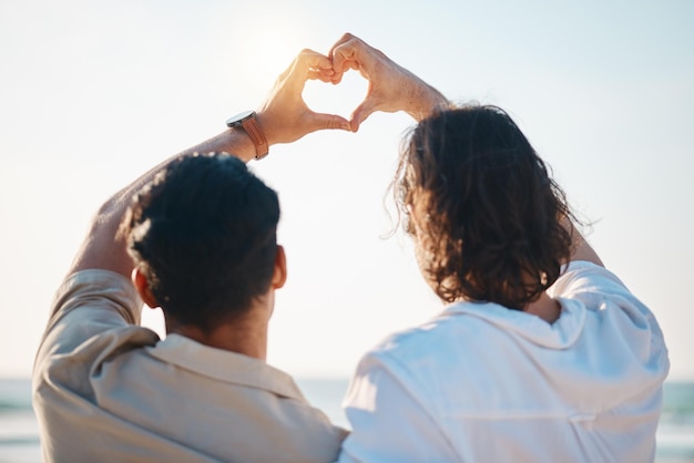 写真 タイで一緒に夏休みに後ろからハートの手とビーチでゲイの男性が抱き合う太陽の光の海とロマンス絵文字 lgbt カップルが自然と休日の中で誇りを持って海と楽しみを抱き合う