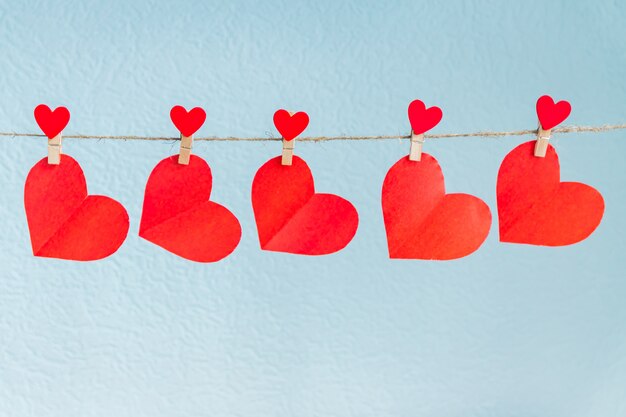 Love hearts hanging on rope on a blue background