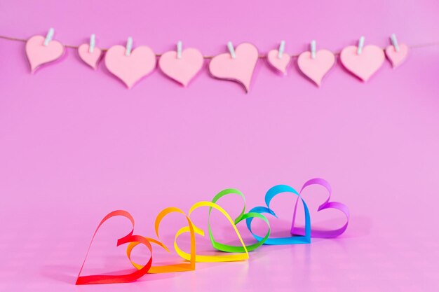 Love hearts with the colors of LGBT on pink background