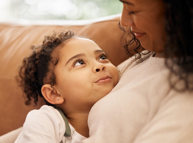 Photo love hug and mother with girl child on a sofa with trust support and bond at home together family relax and face of kid embrace mom in a living room with conversation safety or security in house