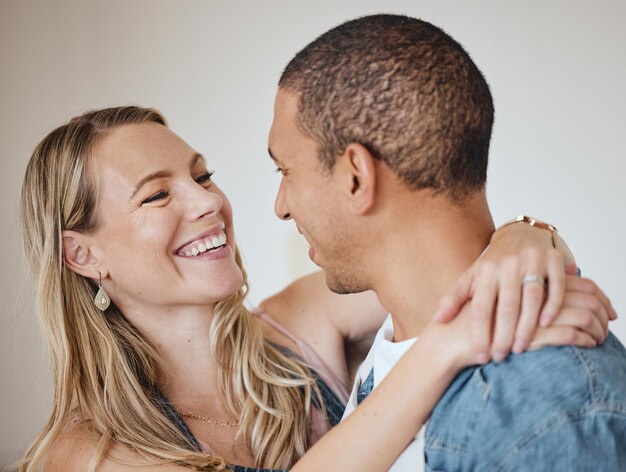 Love hug and smile with a diversity couple in studio on a gray background for romance or affection Trust safe and together with a man and woman hugging while bonding dating or loving