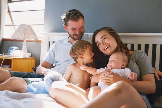 Love is a new addition to the family Shot of a young family of four bonding in the bedroom