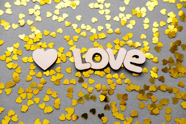 Love is a yellow heart on a gray table on Valentine's Day.