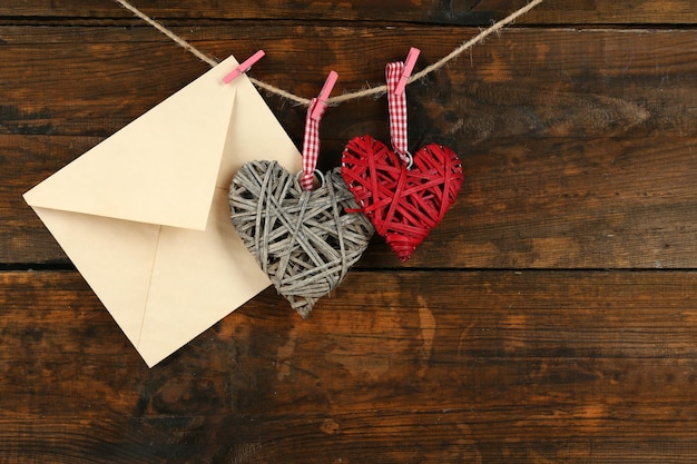 Love letter hanging on rope on rustic wooden background