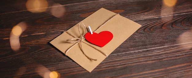 Lettera d'amore con un cuore su uno sfondo di luci amore e concetto di san valentino su un tavolo di legno