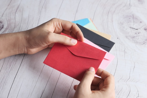 Photo love letter in women hand on red, top view.