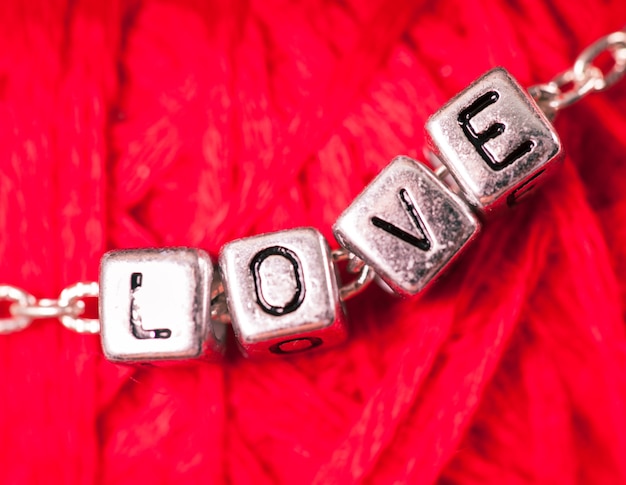 Love letters on the chain close up on red background