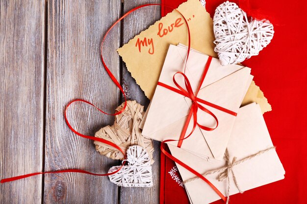 Love letters and hearts on wooden background